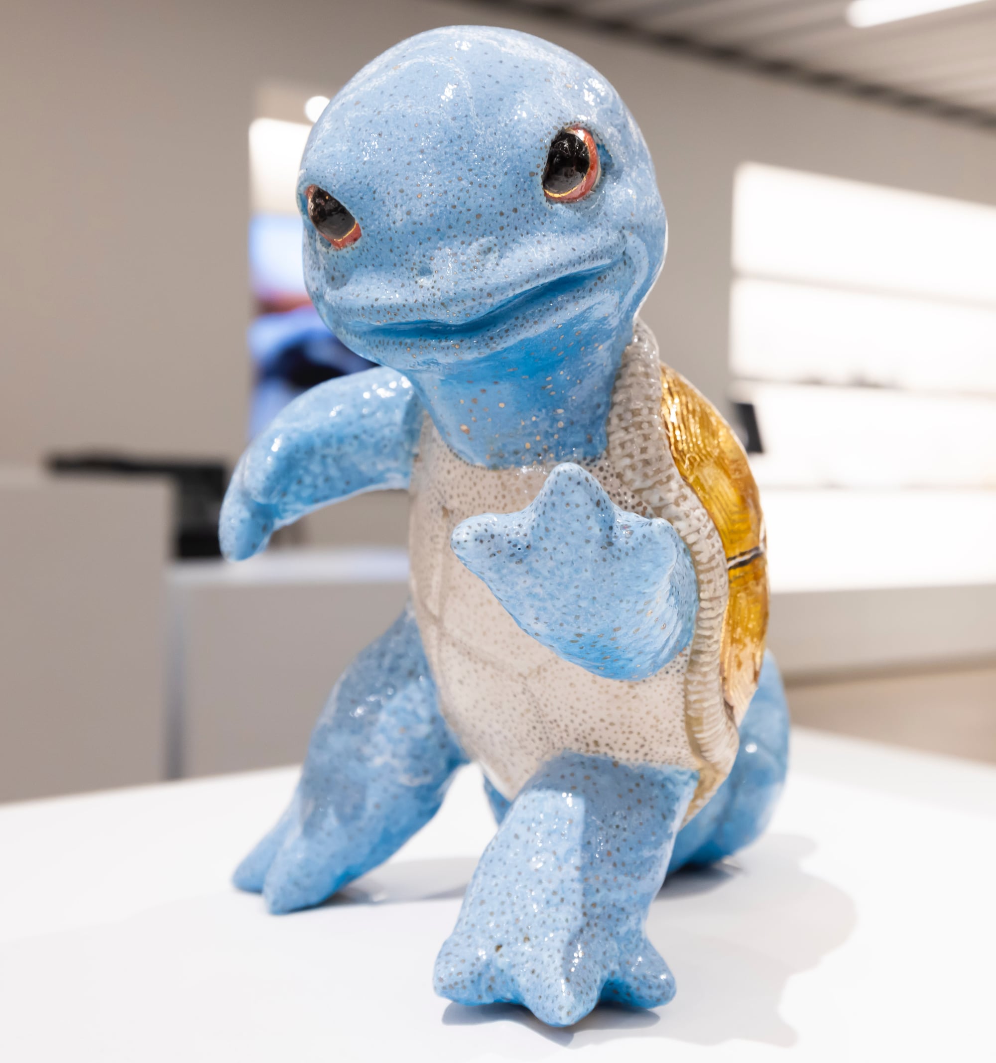 a ceramic sculpture of a blue turtle-squirrel hybrid