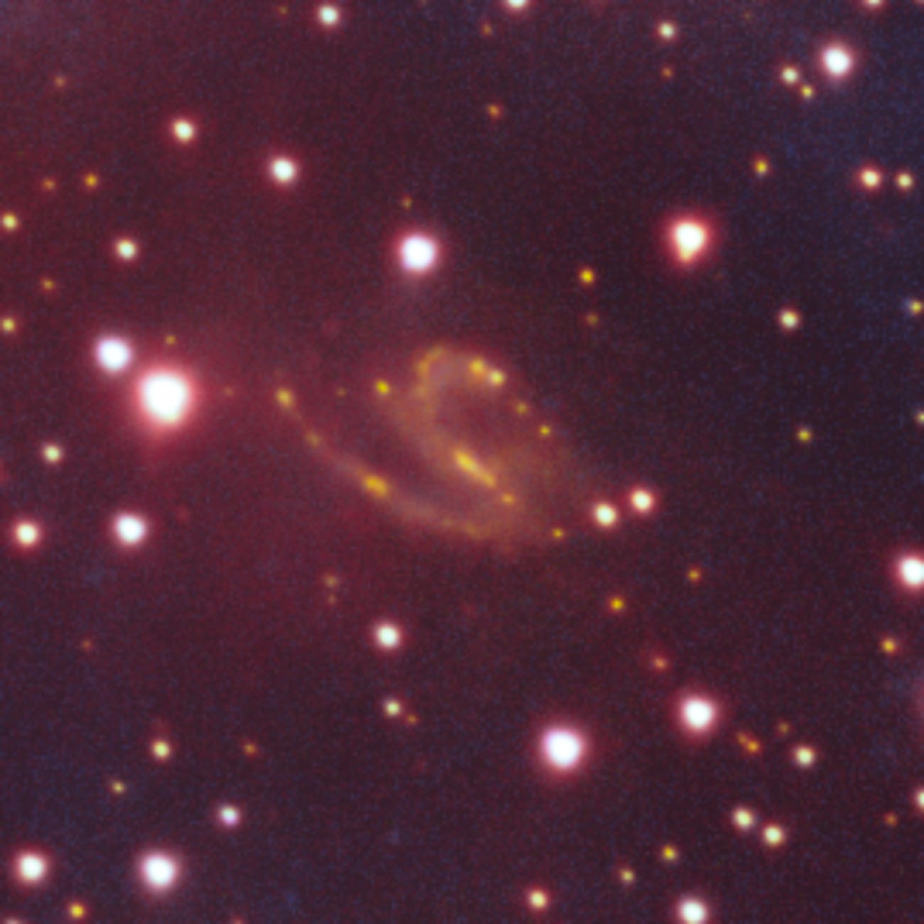 a small swirling galaxy amid stars
