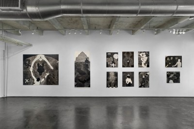 View of a gallery exhibition showing a number of black-and-white prints of different sizes. 