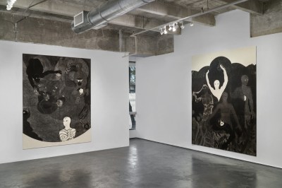 View of a gallery exhibition showing two large-scale black-and-white collagraphs. 