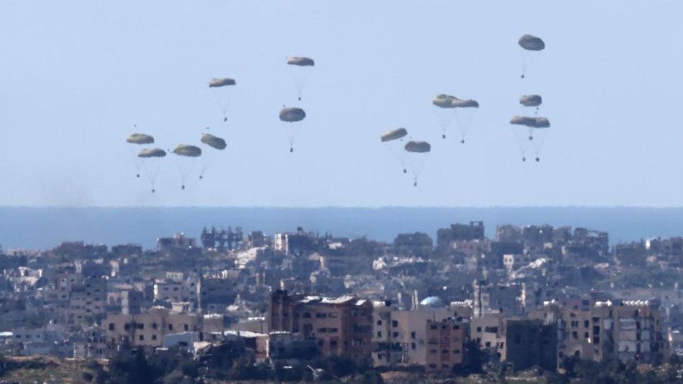 Humanitarian aid is airdropped by an unidentified military transport aircraft over northern Gaza