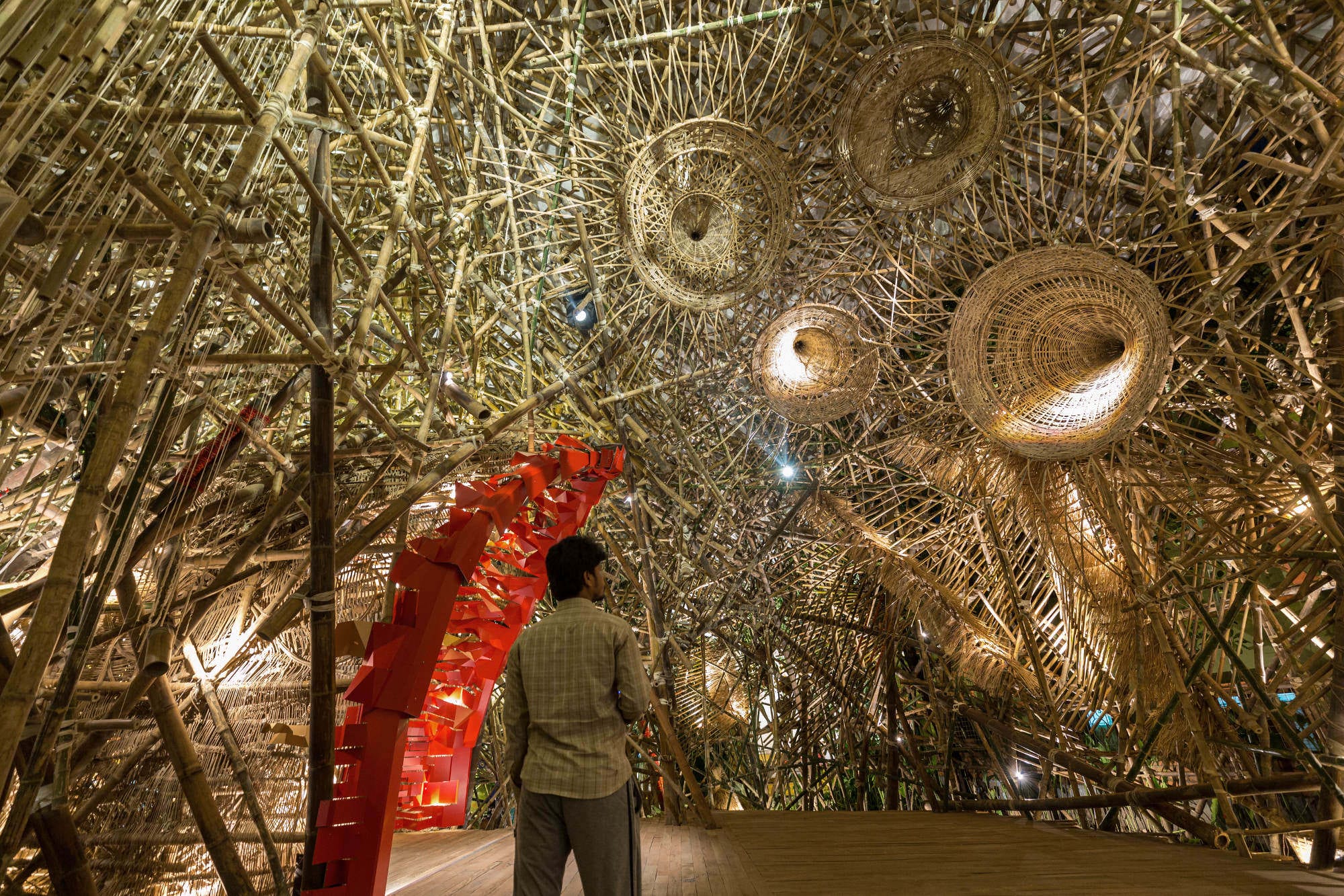 a person wanders into a large bamboo installation 
