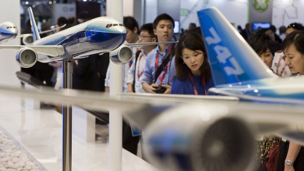 Visitors to the Singapore Airshow look at Boeing's latest display of products