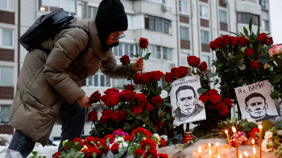 A woman lays flowers in memory of Alexei Navalny