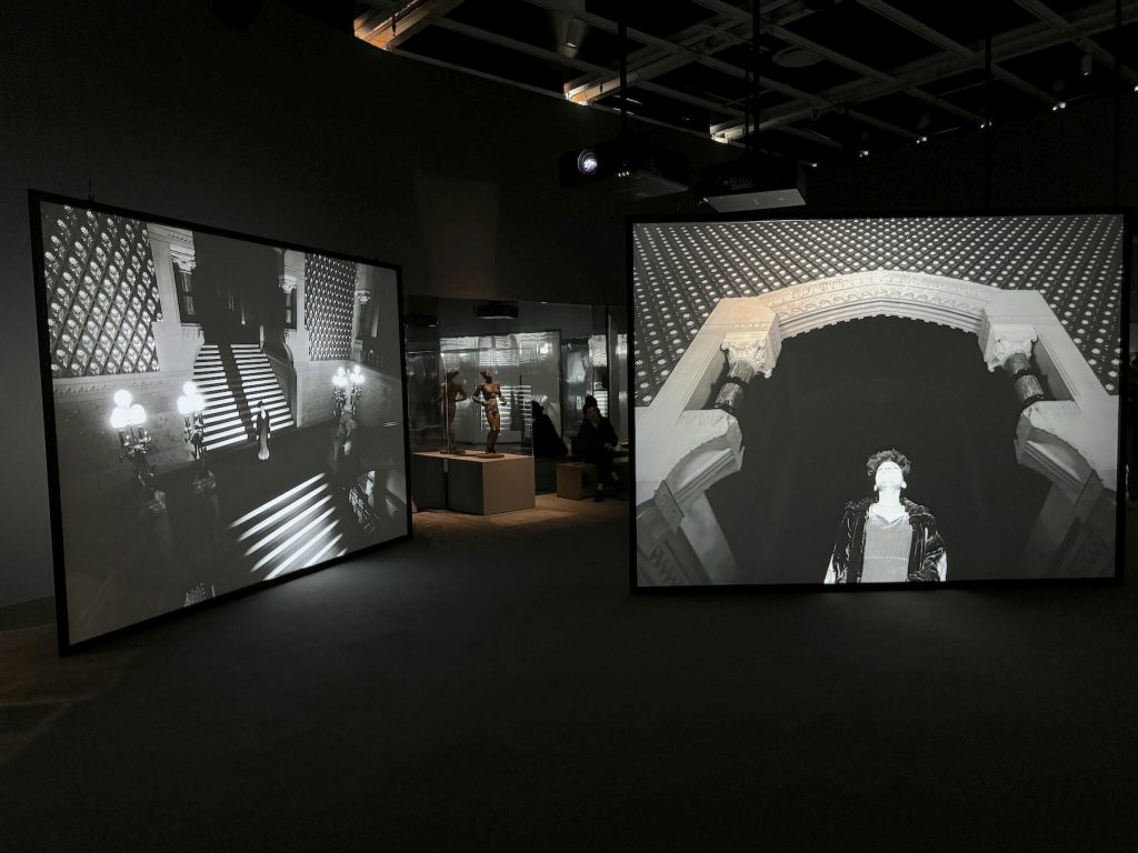 Installation view of video screens playing black and white images in a gallery