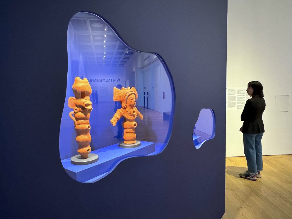Several terra-totta figures displayed in a cubby in an art gallery