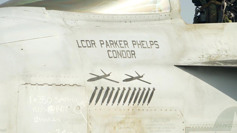 Side of jet cockpit is painted with two jet silhouettes and a number of bombs