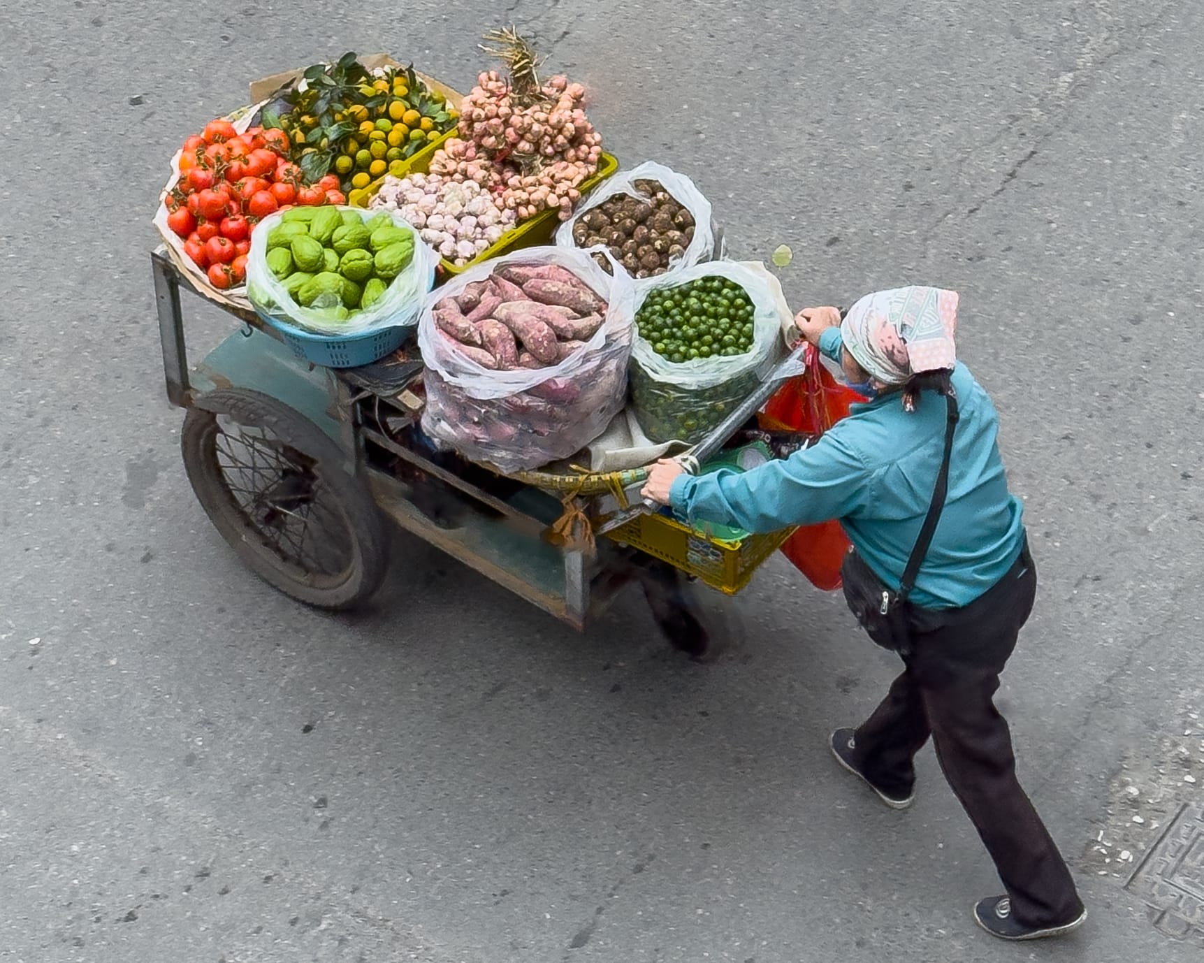 a photo showing a merchant wheeling produce to market